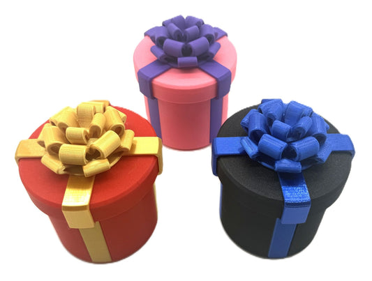Set of colorful gift boxes in red, pink, and black with decorative bows, part of the Annoying Gift Box Prank Set - Hilarious Gag Gift Box Puzzle Challenge for Cash.