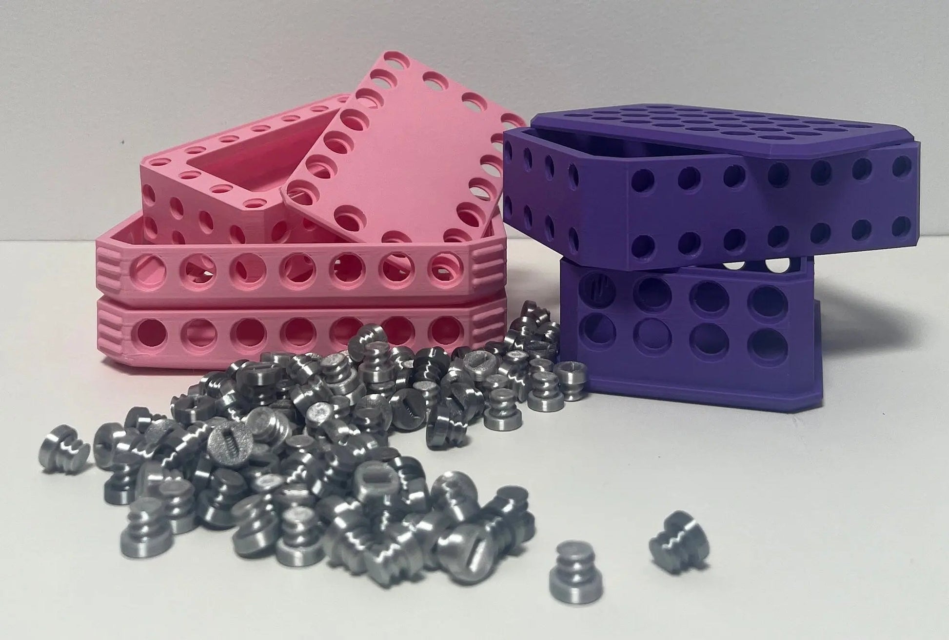 Challenging Card Holder Gift Box in Purple, Pink, and Silver showcasing colorful boxes alongside shiny silver items on a clean surface.