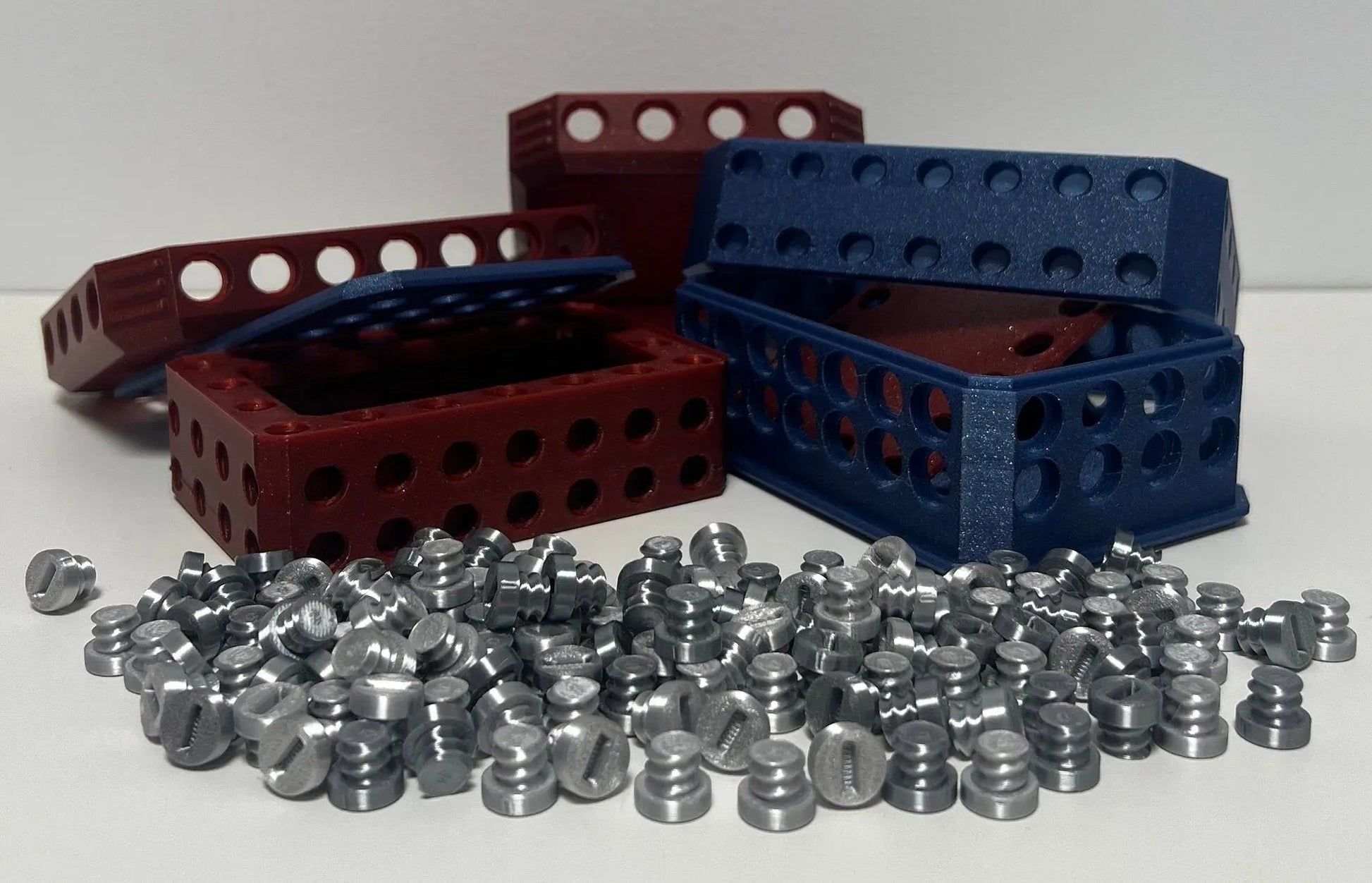 Sparkling Challenge Box: Ultimate Gift with 134 Screws for Fun showcasing two intricately designed boxes in red and blue colors, surrounded by an array of silver screws on a white background.