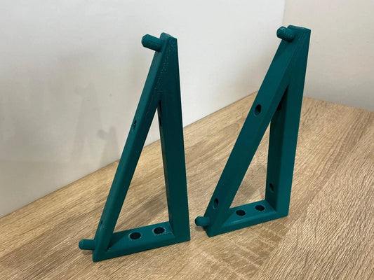 Makita 18V Dual Charger Wall Mount brackets in teal color on a wooden surface, designed for durable and space-saving storage.