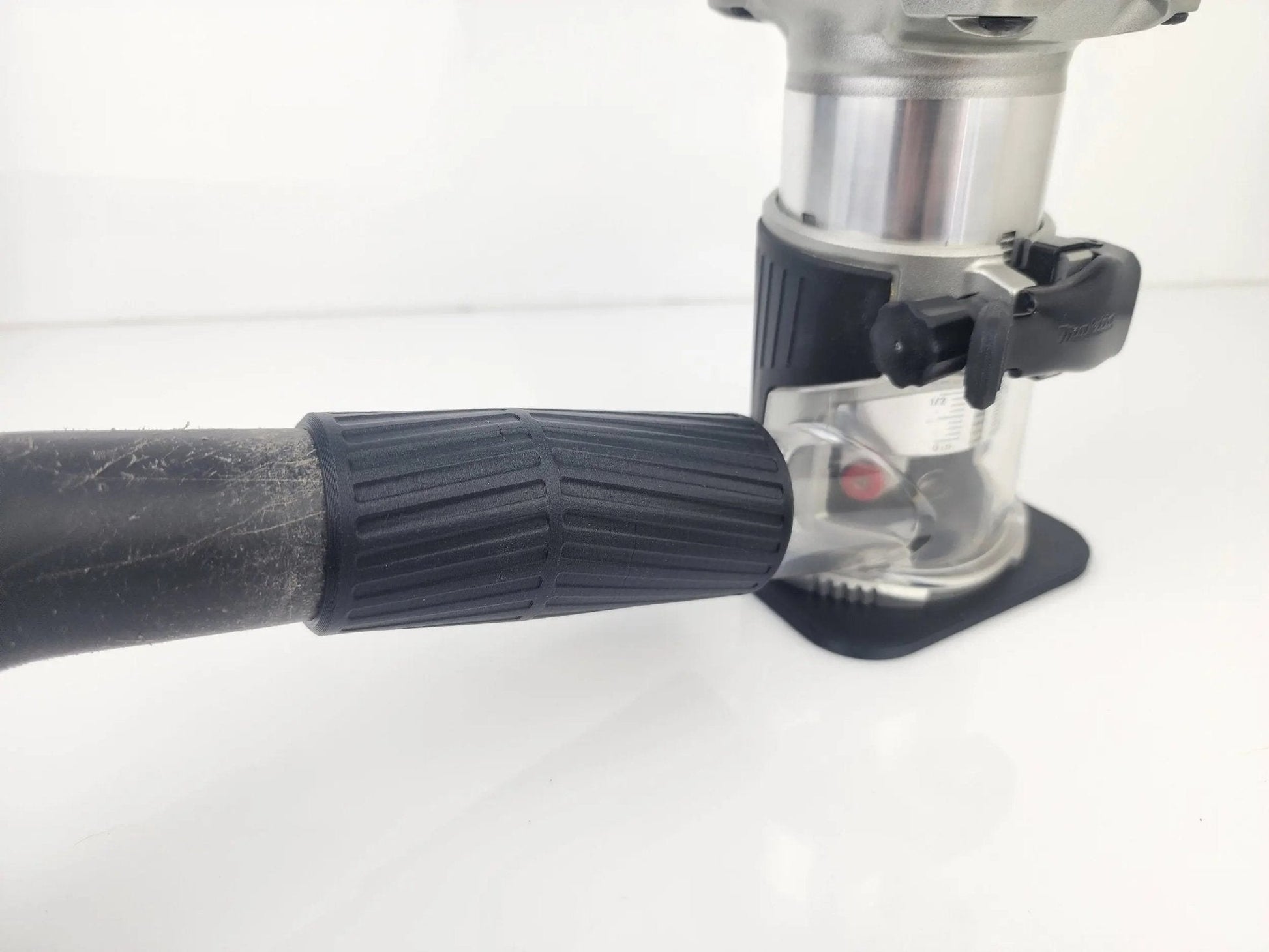 Close-up of the Makita 18V Router Vacuum Adaptor attached to a router, showcasing the dust collection accessory designed for 18V routers to maintain clean workspaces.