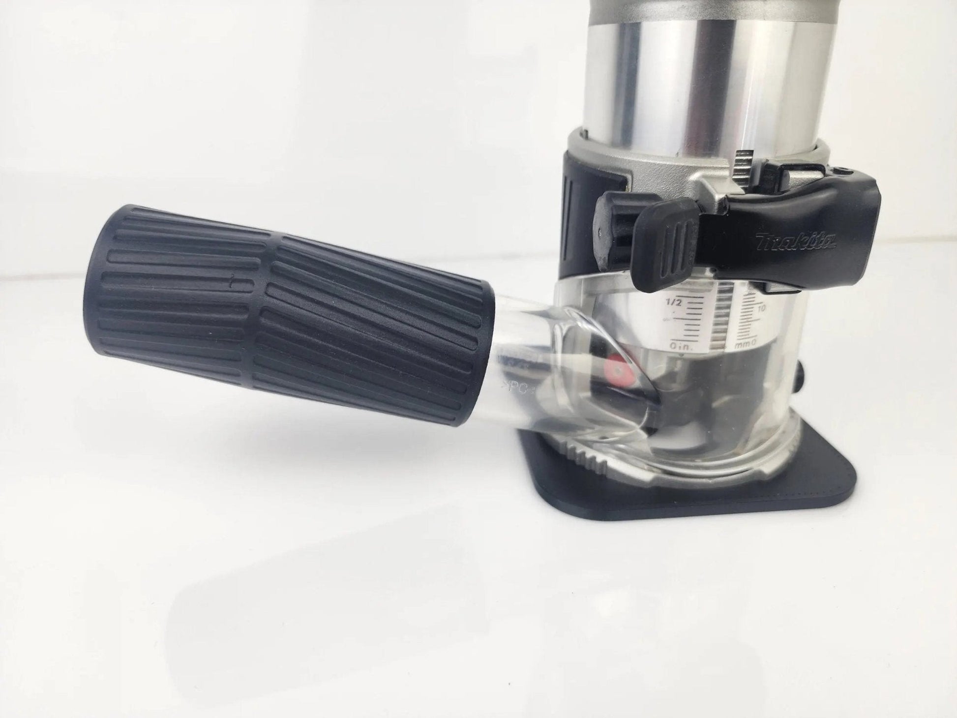 Detailed view of the Makita 18V Router Vacuum Adaptor fitted to a router, illustrating its ergonomic design and functionality for efficient dust collection in woodworking projects.