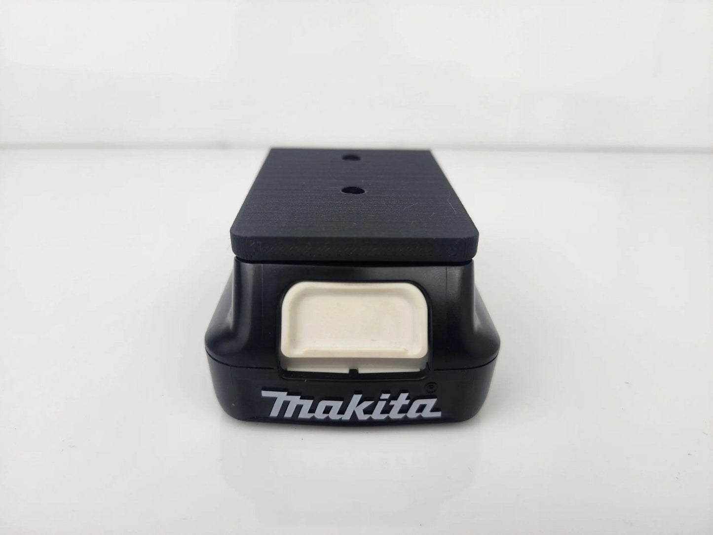 Detailed view of the Makita M12 Wall-Mountable Battery Holder, emphasizing its durable materials and convenient design for battery storage.