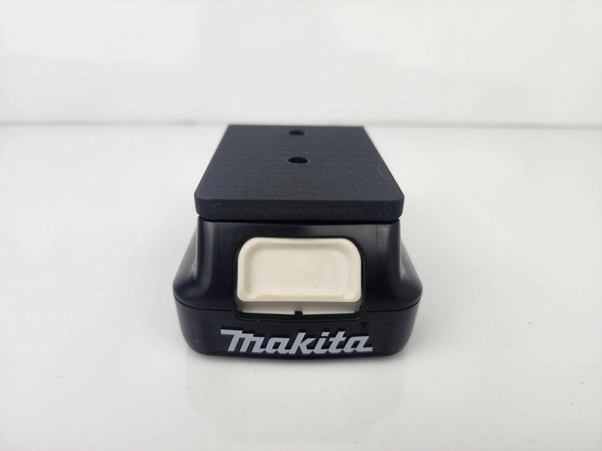 Detailed view of the Makita M12 Wall-Mountable Battery Holder, emphasizing its durable materials and convenient design for battery storage.