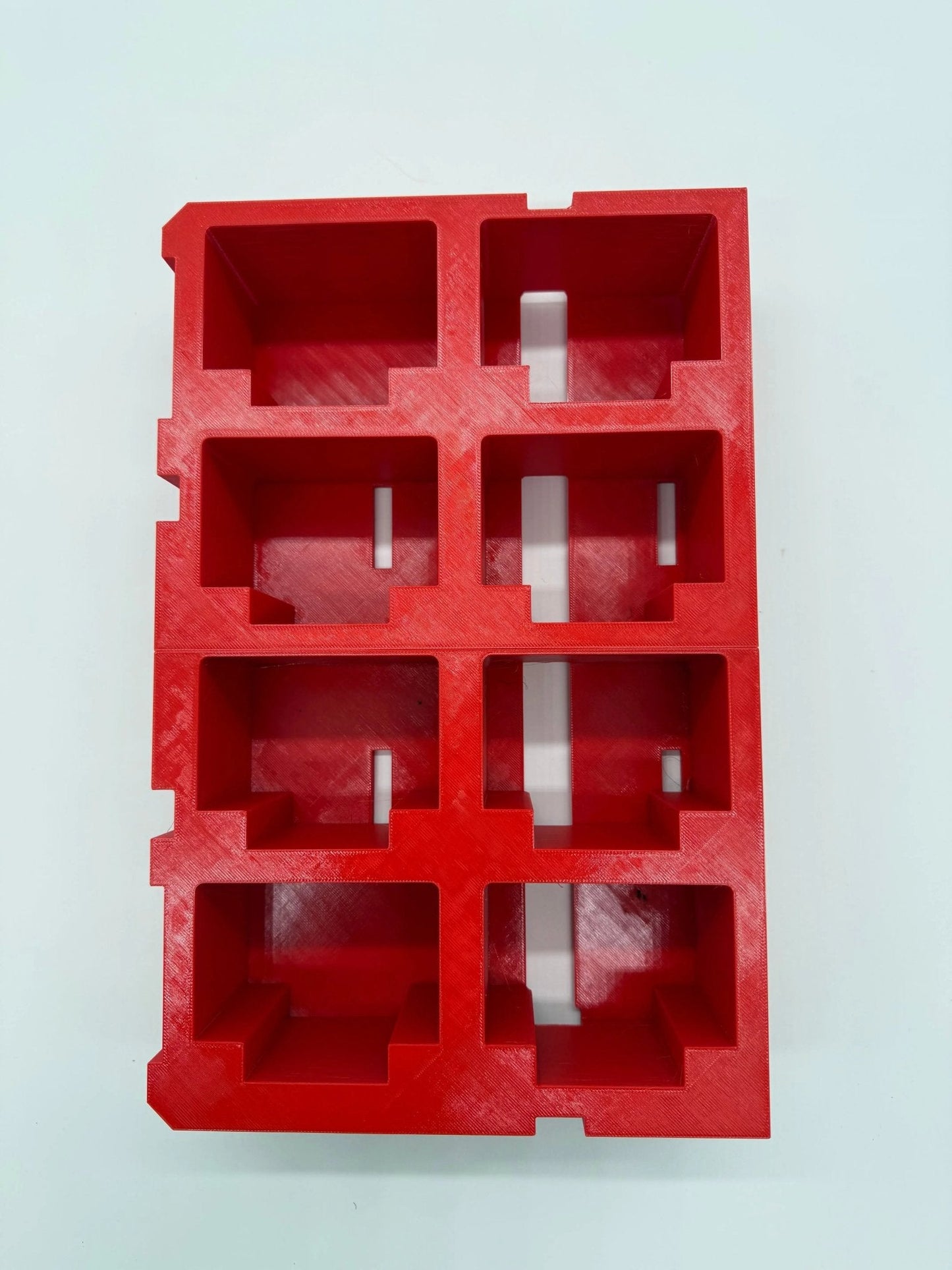 Packout Insert for M18 5.0Ah Battery – Top view of a red plastic battery storage insert with compartments designed for batteries, promoting organization and protection.