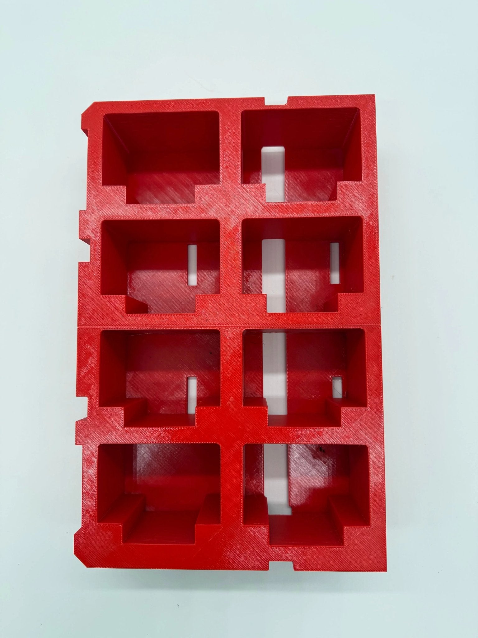 Packout Insert for M18 5.0Ah Battery – Top view of a red plastic battery storage insert with compartments designed for batteries, promoting organization and protection.