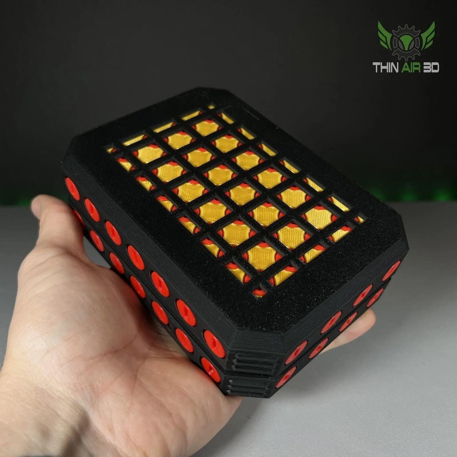 A hand holding the Ultimate Gift Card Box with 4 Screw Puzzle Opening, featuring a black base and red accents, emphasizing its interactive and stylish design.
